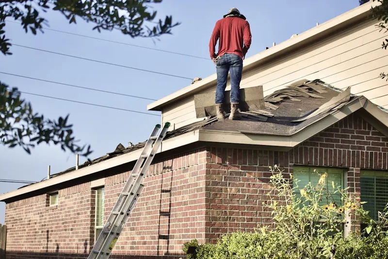Professional roofer working on a residential roof in Goshen Commons